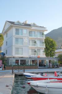 a large white building with boats in the water at Orka Boutique Hotel in Fethiye