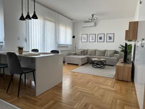 a kitchen and living room with a table and a couch at Apartment Aura in Belgrade