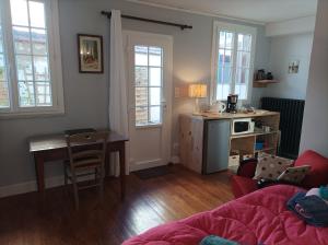 a living room with a table and a kitchen at Au coeur de la cité des Bourbons in Moulins