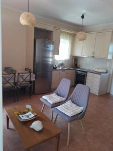 een keuken met 2 stoelen, een tafel en een koelkast bij Nafplio cozy maisonette in Nafplio