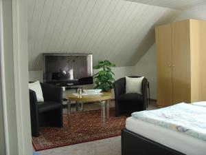 1 dormitorio con TV, mesa y sillas en Am Märchenturm, en Blankenburg