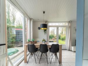 a dining room with a table and four chairs at Welcoming holiday home in Baarland with fenced garden in Baarland