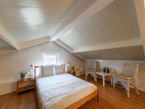 a bedroom with a bed and two chairs at Welcoming holiday home in Baarland with fenced garden in Baarland