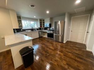 a kitchen with wooden floors and stainless steel appliances at 3BR 2BA Home at Cross Timbers in Mineral Wells