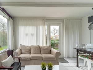 a living room with a couch and a table at Modern holiday home in Baarland with terrace in Baarland