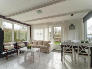 a living room with a couch and a table at Modern holiday home in Baarland with terrace in Baarland
