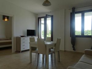 a dining room with a table and chairs and a couch at Residence San Bull in Metaponto
