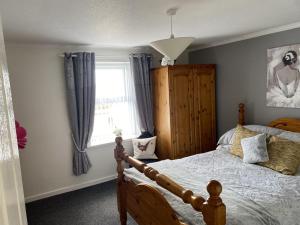 a bedroom with a bed and a window at Fishermans Cottage in Killough