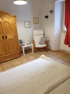 a bedroom with a bed and a chair and a table at Lou-Pelou in Gravières