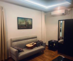 een woonkamer met een bank en een tafel bij SunsetHomes A luxurious studio apartment in Imphal