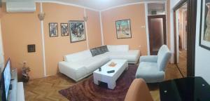 a living room with a white couch and a table at Shangri La Residence in Niš