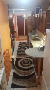 a small kitchen with a table and a rug at Shangri La Residence in Niš