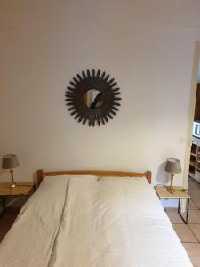 - une chambre avec un lit et un miroir mural dans l'établissement Lou-Pelou, à Gravières
