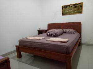 a bed with two pillows and two towels on it at Omah Ndanu Homestay in Yogyakarta