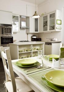 ブダペストにあるブダペスト ルームズ ベッド＆ブレックファーストのキッチン(緑の皿が並ぶテーブル付)