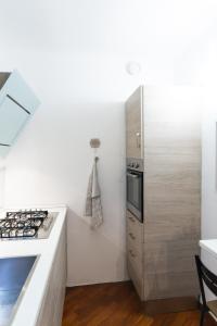 SWEET HOUSE CORSO GENOVA في ميلانو: مطبخ مع موقد وثلاجة