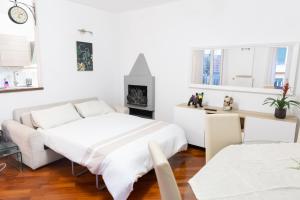 SWEET HOUSE CORSO GENOVA في ميلانو: غرفة نوم بيضاء مع سرير ومدفأة