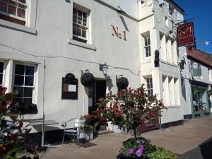 een wit gebouw met een tafel en stoelen ervoor bij No1 Hotel in Wooler