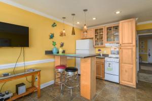 a kitchen with yellow walls and a counter with stools at Love Shack in Tybee Island