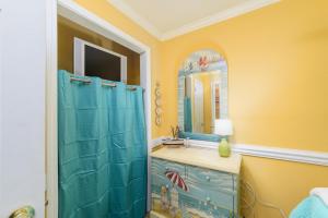 a bathroom with a blue shower and a sink at Love Shack in Tybee Island