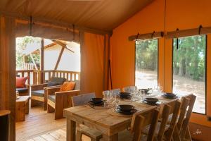 a dining room with a wooden table with glasses on it at Camping U Casone - Maeva in Ghisonaccia