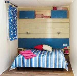 a bedroom with a bed with pink towels on it at Camping U Casone - Maeva in Ghisonaccia