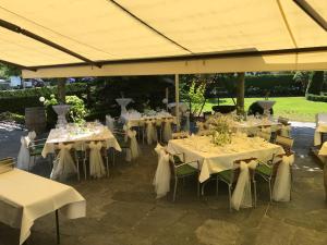 eine Gruppe von Tischen mit weißen Tischdecken in der Unterkunft Hotel Restaurant Rössle in Rankweil