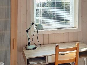 a lamp sitting on a desk next to a window at Two-Bedroom Holiday home in Stege 5 in Grevinge