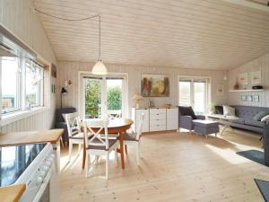 a dining room and living room with a table and chairs at Two-Bedroom Holiday home in Stege 5 in Grevinge