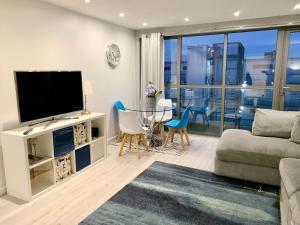 a living room with a television and a table and chairs at Stylish Apartment Close to London Bridge in London