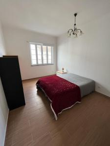 a bedroom with a large bed with a red blanket at Casa da Luz in Angra do Heroísmo