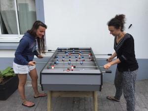 Deux femmes se tenant à côté d'un billard dans l'établissement Spotsleeping, à Anglet