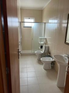 a bathroom with two toilets and a sink and a mirror at Casa da Luz in Angra do Heroísmo