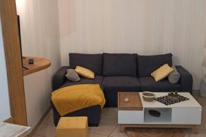 a living room with a blue couch and a table at Petite maison de bourg proche A84 in Ducey