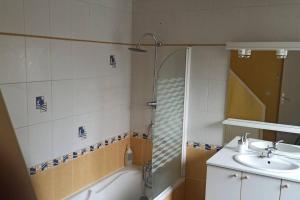 a bathroom with a tub and a sink and a shower at Petite maison de bourg proche A84 in Ducey