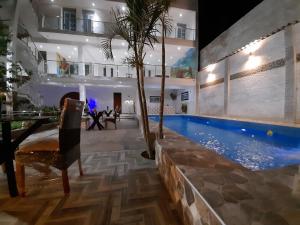 uma villa com uma piscina e uma sala de jantar em La Posada 815 em Pisco