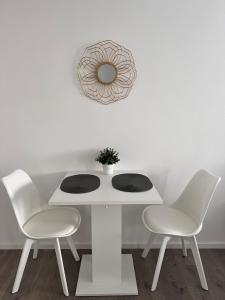 une table blanche avec deux chaises et un miroir dans l'établissement Sophie Flair Apartment, à Karlsruhe