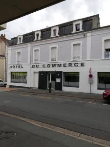 um edifício branco ao lado de uma rua em Hotel du Commerce em Cholet