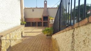 a brick walkway with a bench and a fence at CASA CUEVA VANESA in Hinojares