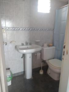 a white bathroom with a sink and a toilet at Alquilo depto 1 dorm en Zárate in Zárate