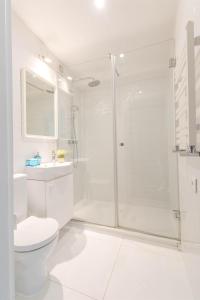 a white bathroom with a shower and a toilet at Krupnicza Modern Old Town Apartments - by Upstairs in Kraków +142 photos