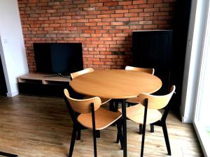 a wooden table and chairs in a room with a brick wall at Apartament Sky Jastrzębia Góra in Jastrzębia Góra