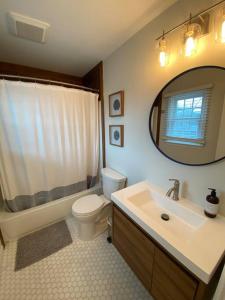 een badkamer met een wastafel, een toilet en een spiegel bij Stunning and Spacious 3br/2.5 ba only a block to the Bay Beaches in Wildwood Highlands Beach