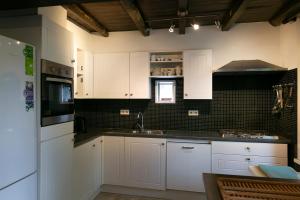 a kitchen with white cabinets and a sink at Landgoed Karel van Yedeghem in Watou