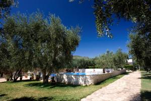 a swimming pool in a park with trees at Villaggio San Matteo Resort in Mattinata
