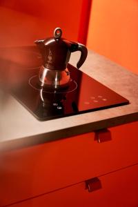 a tea kettle sitting on a tray on a counter at Urbanauts Studios Minelli in Trieste