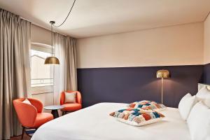 トリエステにあるURBANAUTS STUDIOS Minelliのベッド1台と椅子2脚が備わるホテルルームです。