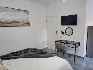 a bedroom with a bed and a desk with a mirror at Egerton Overnight in Kimberley