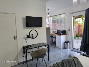 a living room with a desk and a tv on a wall at Egerton Overnight in Kimberley
