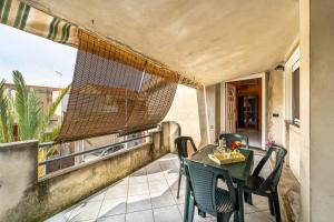 patio ze stołem i krzesłami na balkonie w obiekcie Casa Flu w mieście Assemini